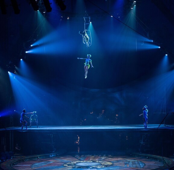 A circus performance with acrobats on a stage. 4