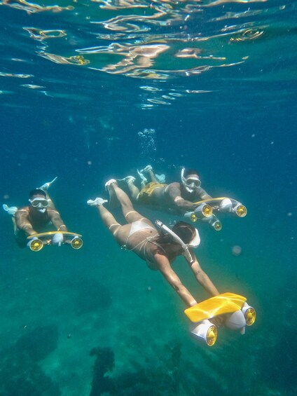 Three people scuba diving underwater. 5