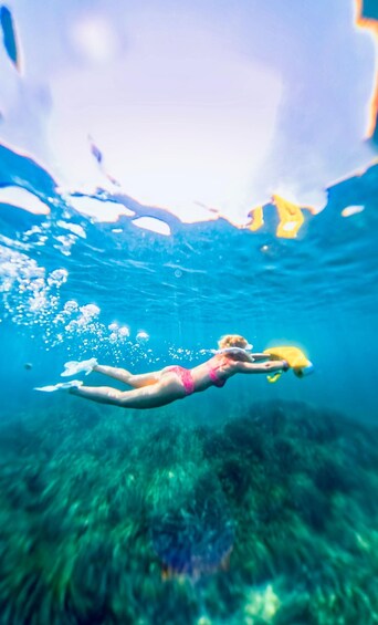 A person swimming underwater with a yellow object. 5