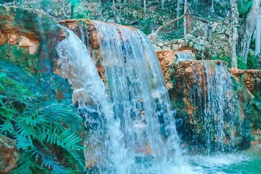 A waterfall cascading over rocks in a forested area. 5