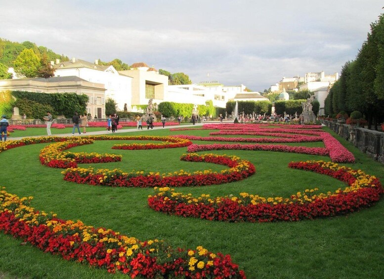 A garden with geometric flower beds and statues. 1