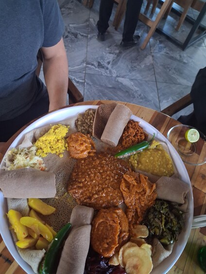 A large plate of Ethiopian cuisine with injera, lentils, and various stews. 1
