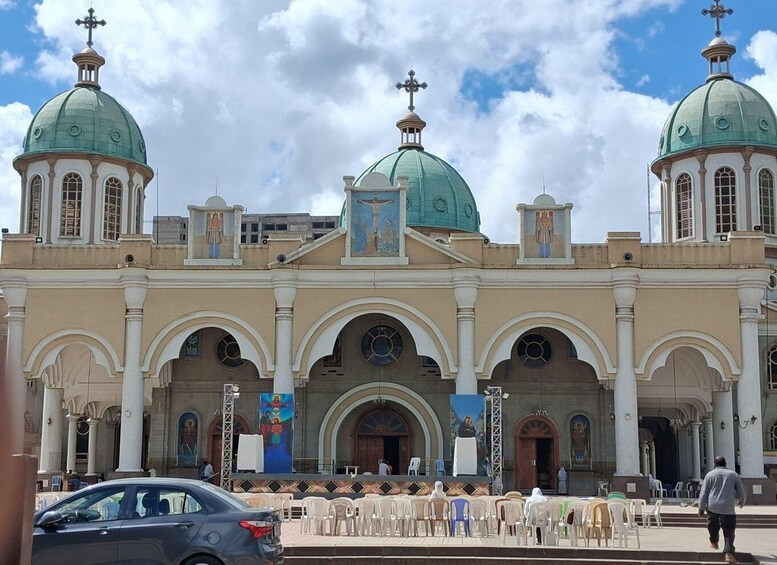 A church with two green domes and a central cross. 3