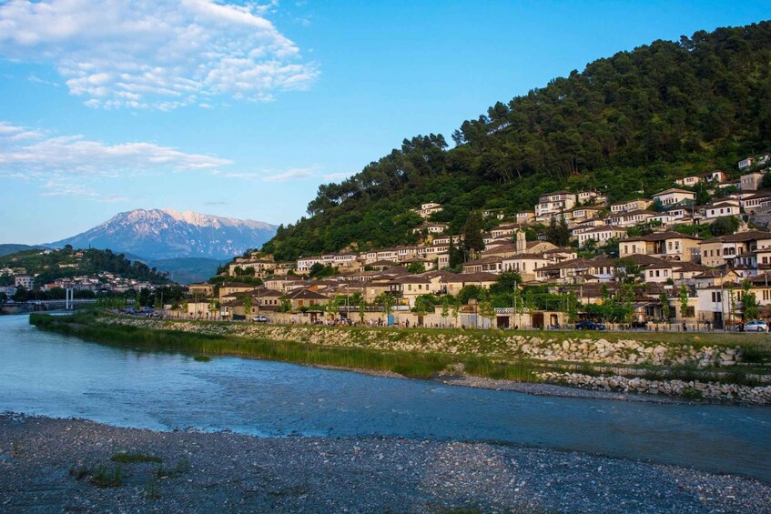 Un río que atraviesa una ciudad con edificios en una ladera y una montaña al fondo. 2