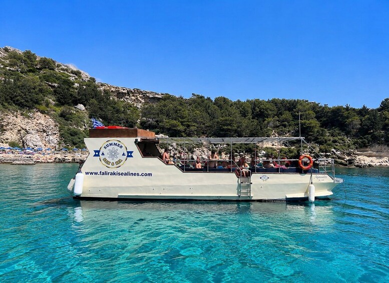 A boat with 'SUMMER SUN & SEA' branding on its side, floating on clear blue water. 4