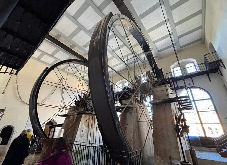 A large, historic clock tower with intricate gears and a metal framework. 3