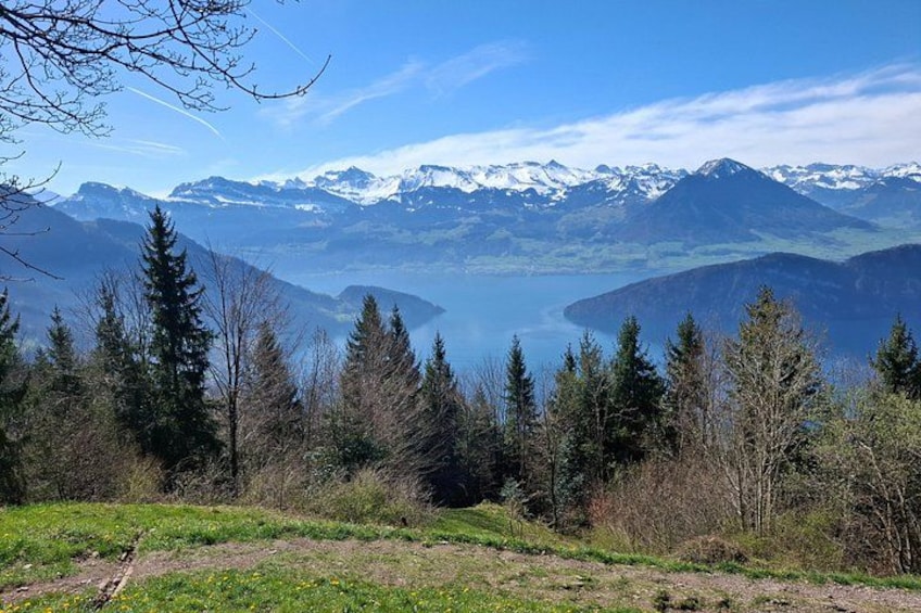 A mountainous landscape with snow-capped peaks, a lake, and coniferous trees. 2