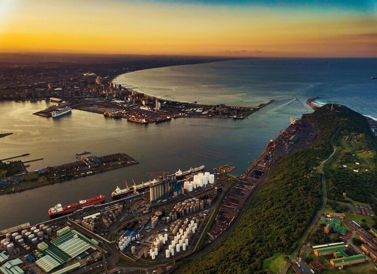 An industrial port with ships, storage tanks, and a large shipyard. 1