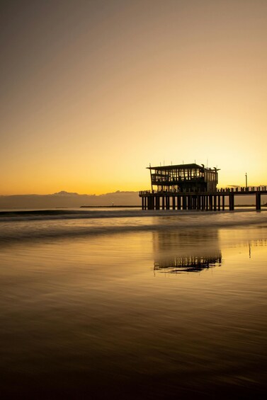 A pier extending into calm waters with a sunset in the background. 3