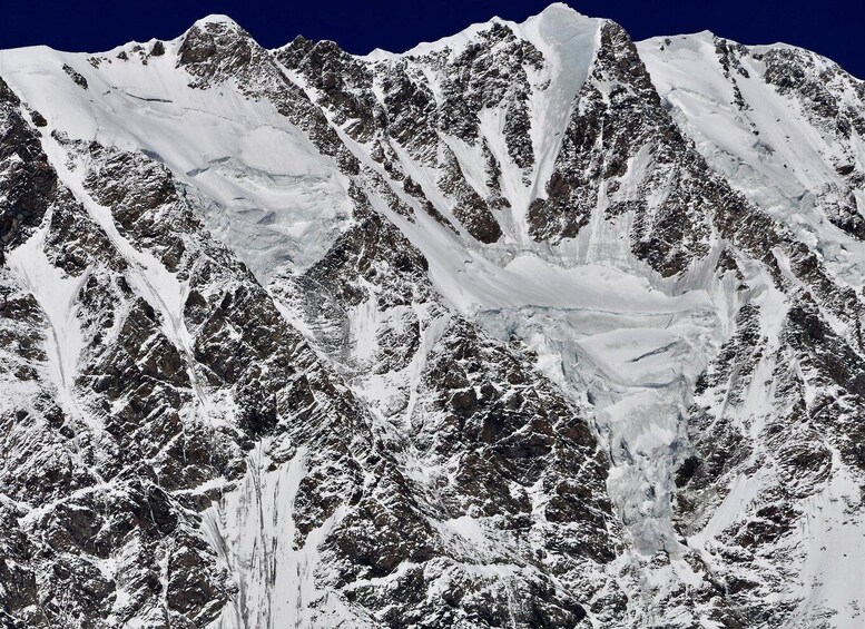 A snow-covered mountain range with sharp peaks and a glacier. 2