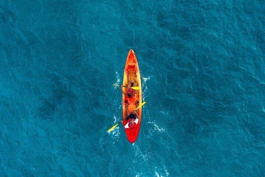 A person kayaking on a blue body of water. 2