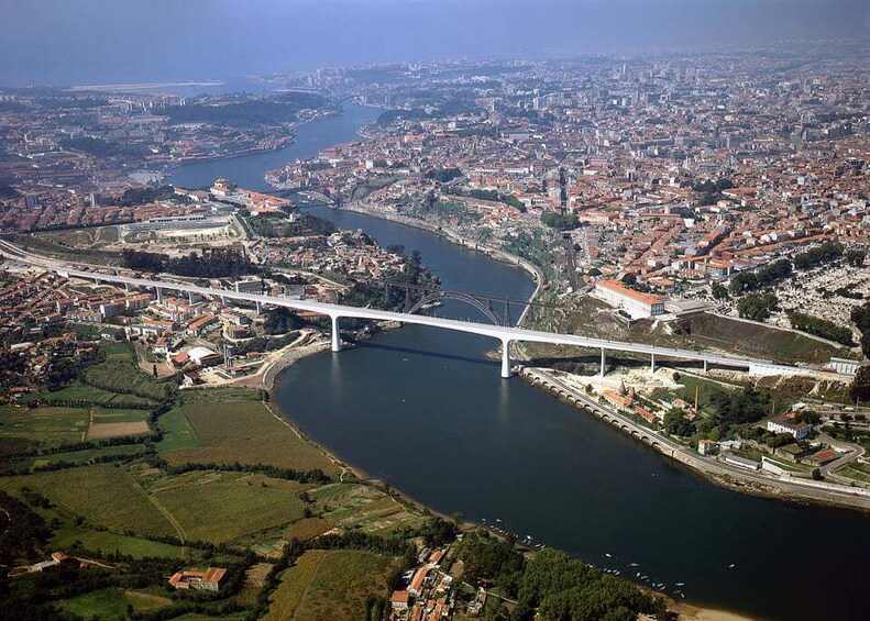 A river with a bridge, a cityscape, and green fields. 5