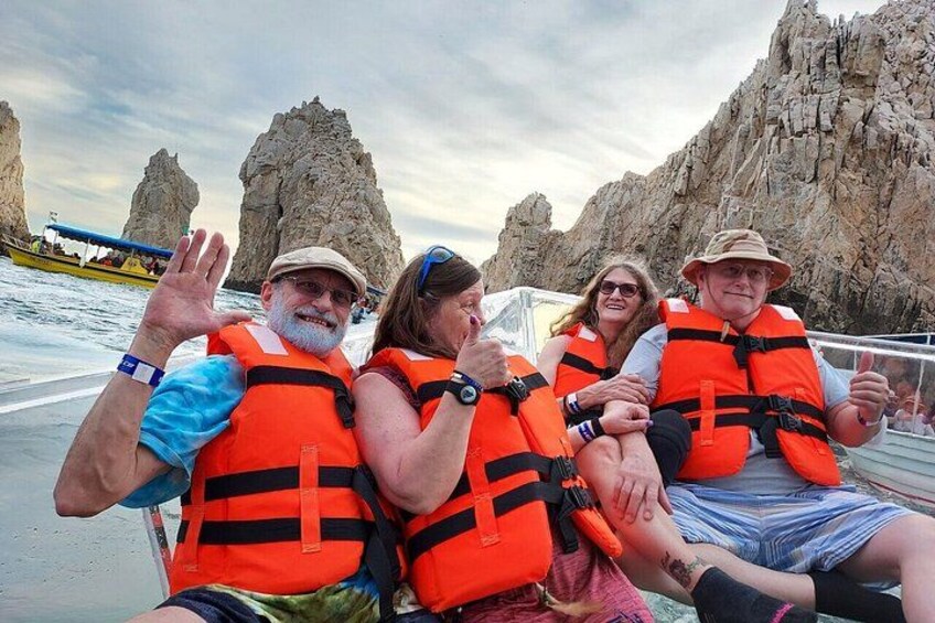 A group of people on a boat wearing life jackets, with rocky formations in the background. 2