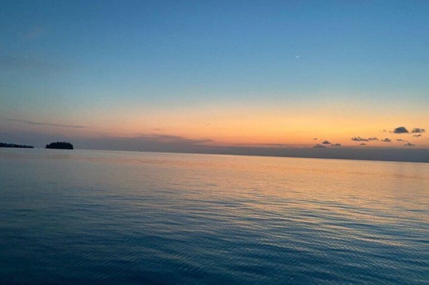A calm sea at sunset with a distant island. 4