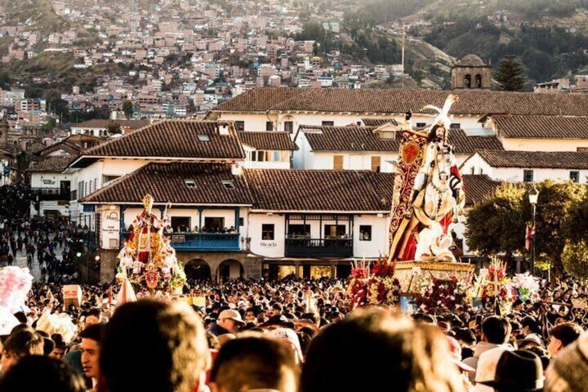 A crowded outdoor event with a large statue and buildings in the background. 5