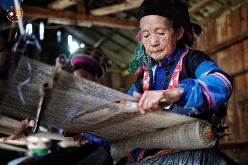 An elderly person weaving with a traditional loom. 2