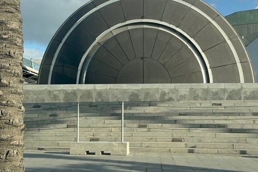 A modern building with a large circular design and a stone staircase leading up to it. 5