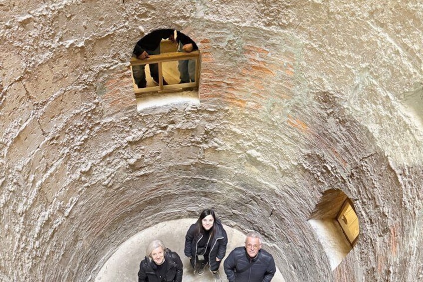 A circular stone structure with three people standing inside. 3