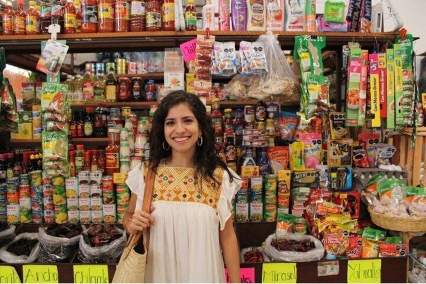 A person standing in front of a store shelf stocked with various food items and packaged goods. 1
