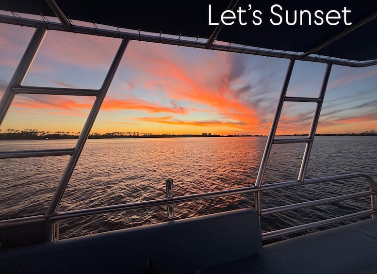 A sunset viewed from a boat with a metal railing. 1