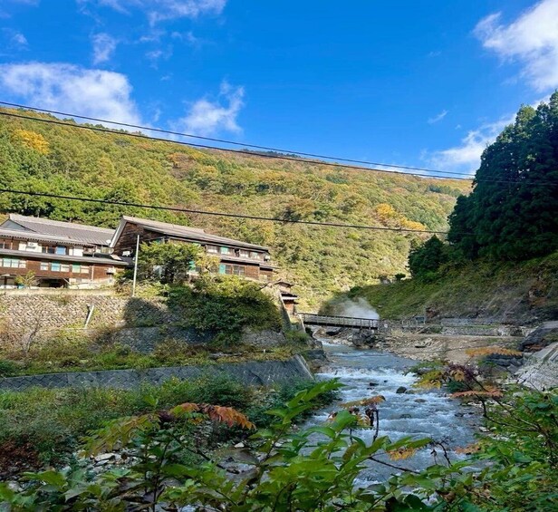 A river flowing through a valley with traditional buildings on the hillside. 1