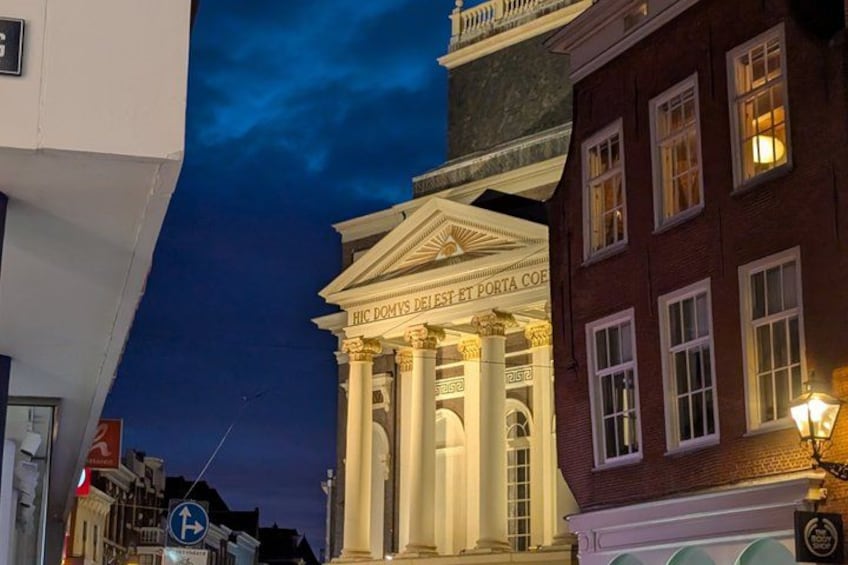A classical building with columns and a sign reading 'HIC DOMUS DEI ET PORTA COELI' at twilight. 3