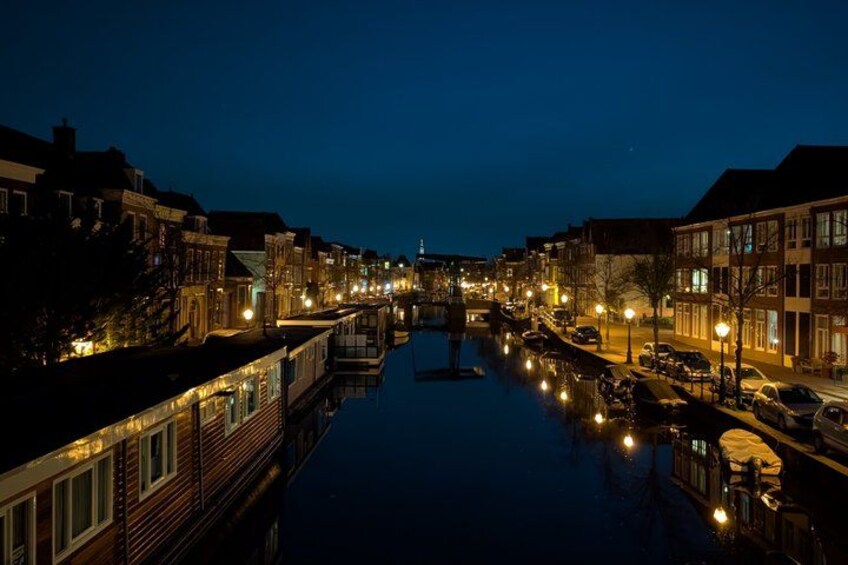 A canal lined with buildings, a bridge, and boats. 4