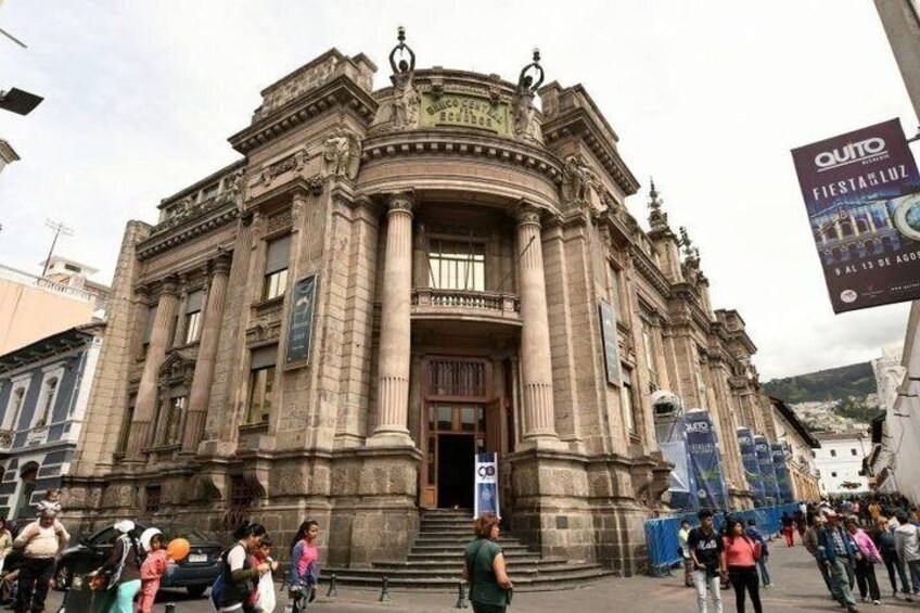 A historic building with ornate architecture, a large entrance, and a crowd of people in front. 3