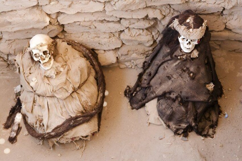 Two mummified figures in a stone-walled tomb. 4