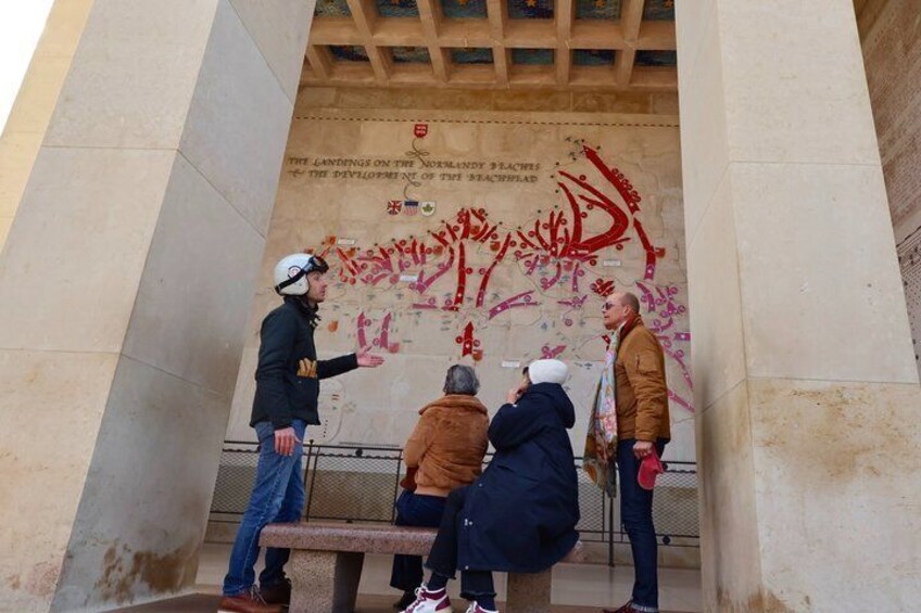 A group of people standing and sitting near a wall with red graffiti and text. 5
