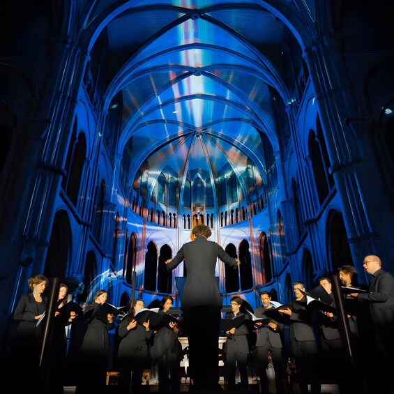 Et kor optræder i en katedral med blåt interiør. 3