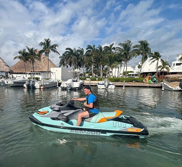 A person riding a Sea-Doo jet ski on calm water with palm trees and boats in the background. 2