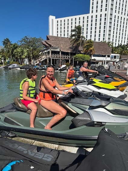 A jet ski with a person and a child on it, a building in the background, and palm trees. 4