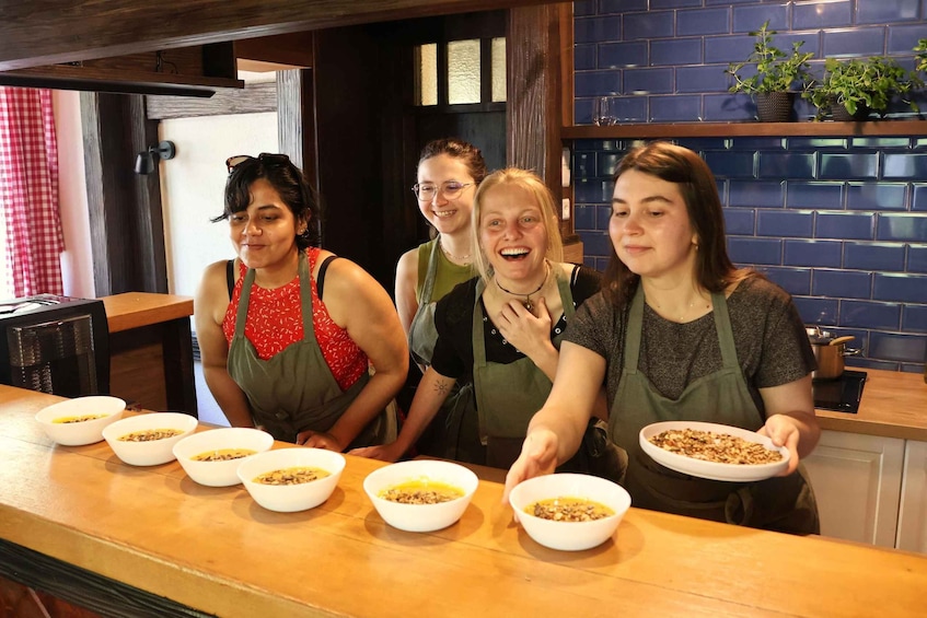 Four people in a kitchen, each holding a bowl of food. 1