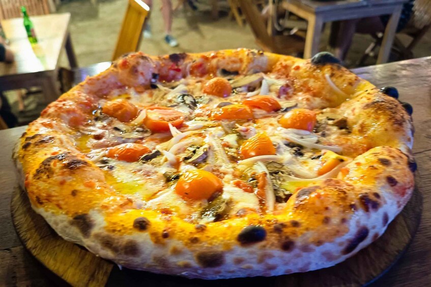 A pizza with various toppings on a wooden board. 4