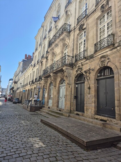 A cobblestone street lined with historic buildings featuring ornate balconies and classic architecture. 4