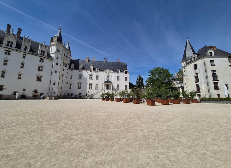 A large courtyard with a historic building featuring multiple towers and a central entrance. 5