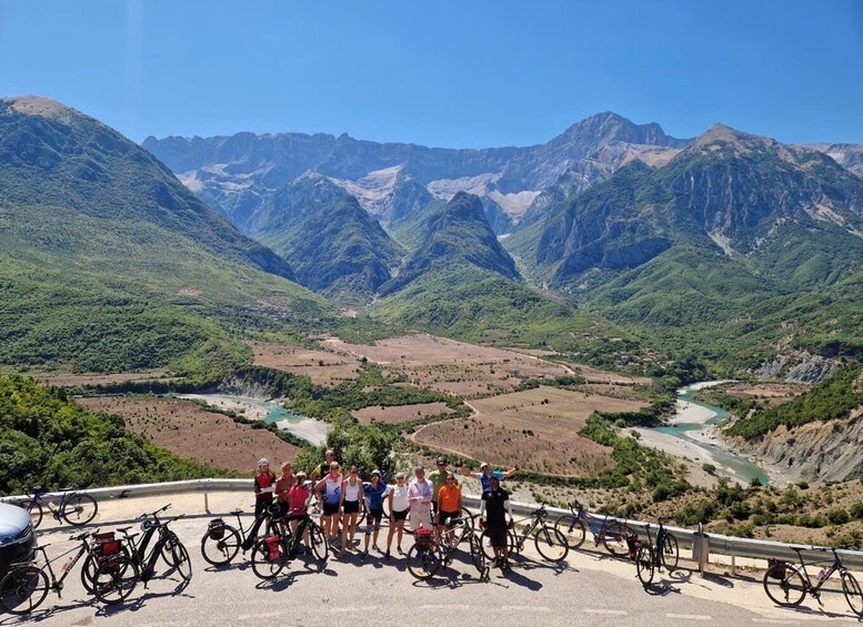 A group of cyclists on a road with a mountainous landscape in the background. 2