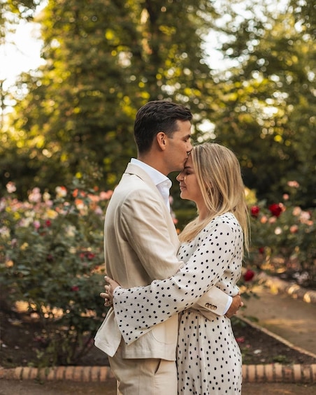 A couple embracing in a garden with blooming roses and trees. 5
