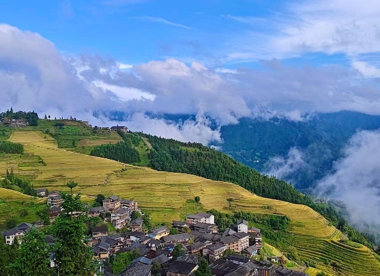 Stufenförmige Reisfelder, ein Dorf und ein Gebirge mit Wolken. 2