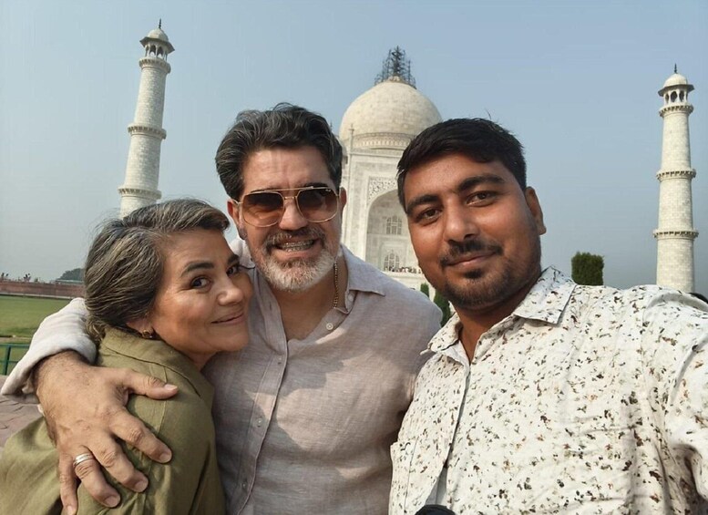 Three people posing in front of the Taj Mahal. 4