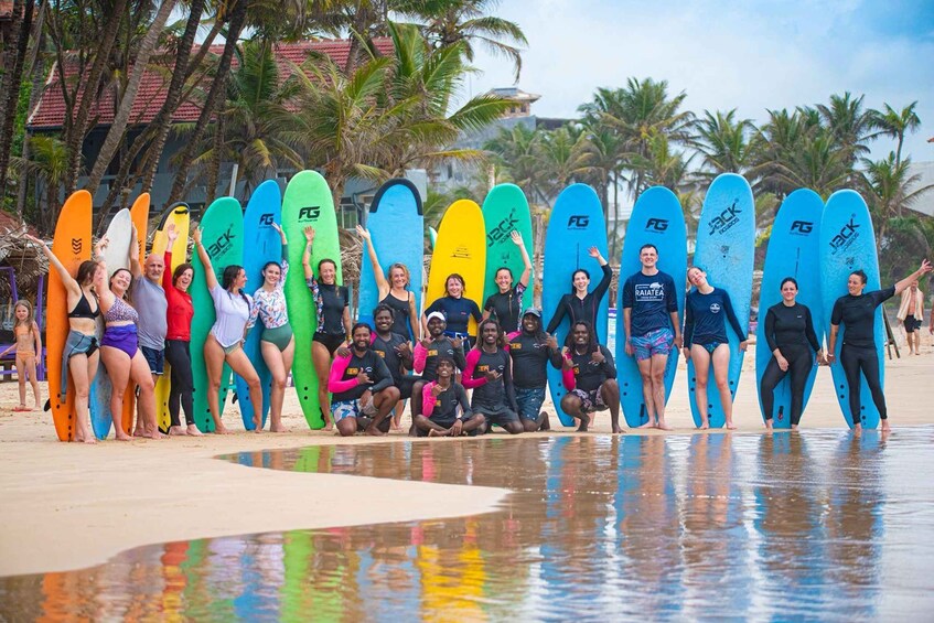 A group of people on a beach holding surfboards. 1