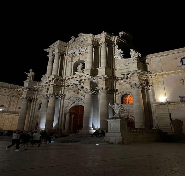 A grand historical building with ornate columns and statues, illuminated at night. 3