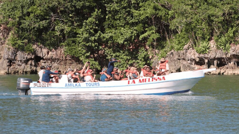 A boat named 'LA MELISSA' with 'AMILKA TOURS' written on it, carrying passengers on a calm body of water. 5