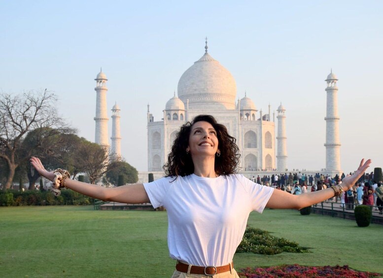 A person standing in front of the Taj Mahal with arms outstretched. 1