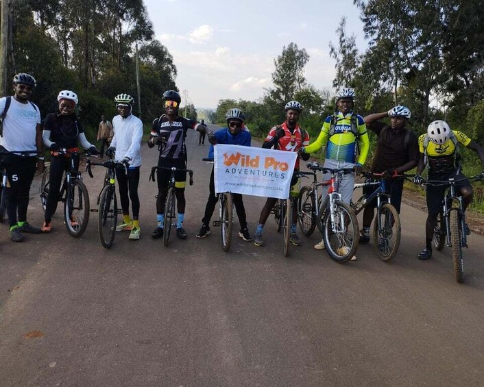 A group of cyclists on a paved road with trees in the background. 3