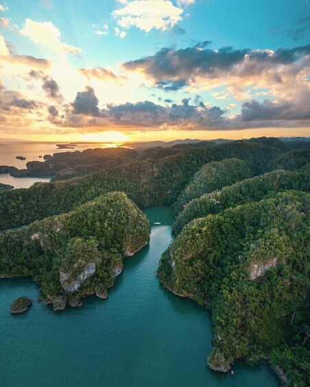 A coastal landscape with dense forests, a river, and a sunset. 3