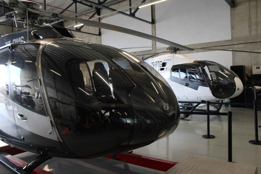 A helicopter with a sleek, reflective surface, mounted on a stand in an indoor exhibition space. 5