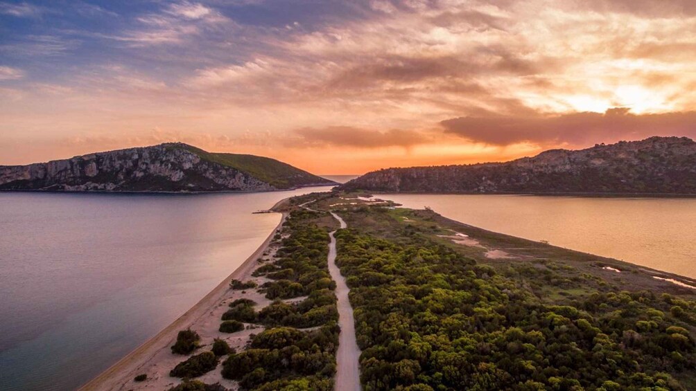 A coastal landscape with a winding road, dense greenery, and rocky hills during sunset. 4