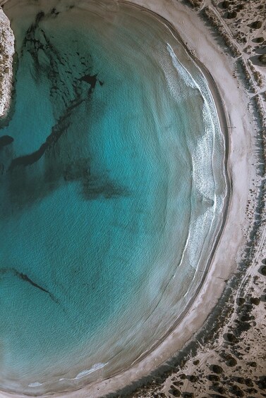 A coastal beach with clear turquoise water and a sandy shoreline. 2